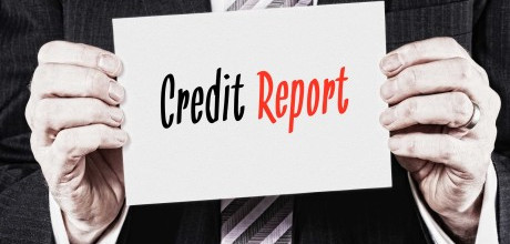 A man in a suit holding a white card that says credit report