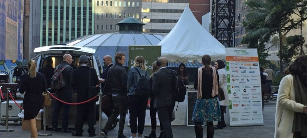 A group of people queing at a CreditSmart stand outside