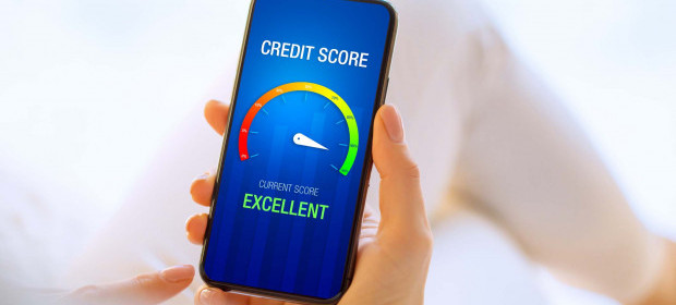 A person holding their phone showing an excellent credit score on the screen